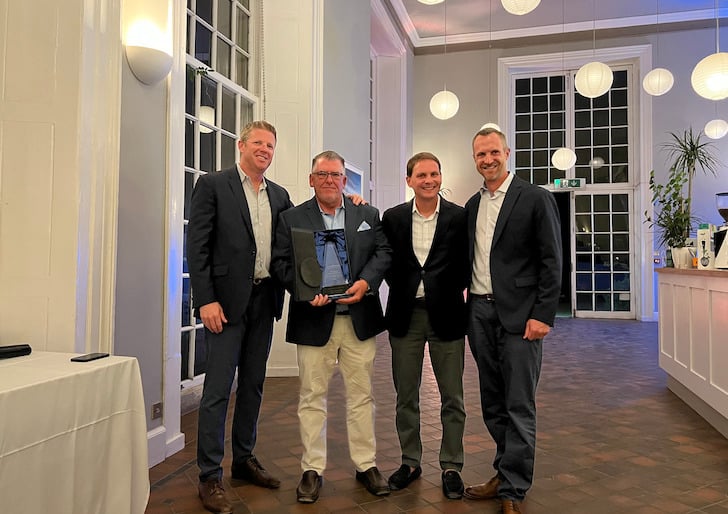 Mike McCarthy and Princess yachts America standing and holding the top broker award for Princess Yachts.
